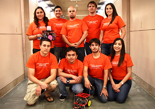 Dr. Mounir Ben Ghalia (pictured back center) with students in orange t-shirts, including Estrella Medina.