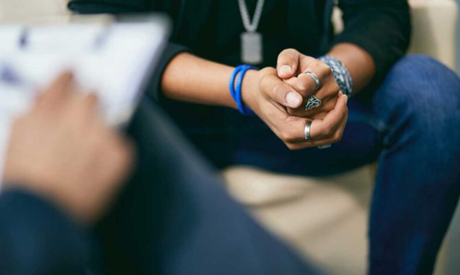 A therapist and patient in a session, with an image focus on the patients hands