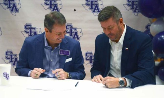 Dr. Neal Weaver, Stephen F. Austin State University president, looks on as Dr. Michael Simon, Angelina College president, signs the agreement making AC the first member of the Lumberjack Transfer Alliance.