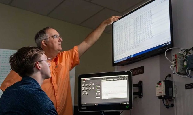 Robert Kaufman, professor of practice at UT San Antonio, works with a student in his information systems and cybersecurity lab.