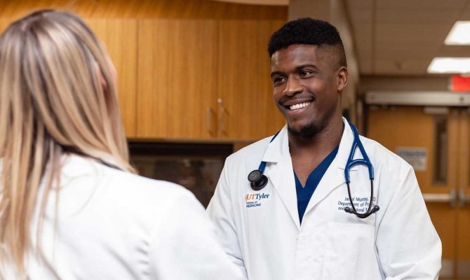 Student  physician assistant talking to another medical student