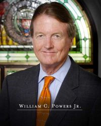 Profile photo of William Powers in front of a stained glass window with the UT Austin seal