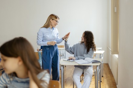 Student and teacher in classroom high five